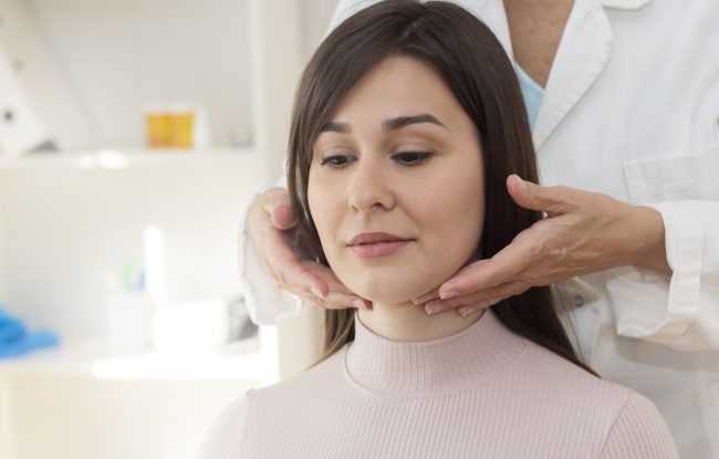 Demonstration of doctor examining patient neck