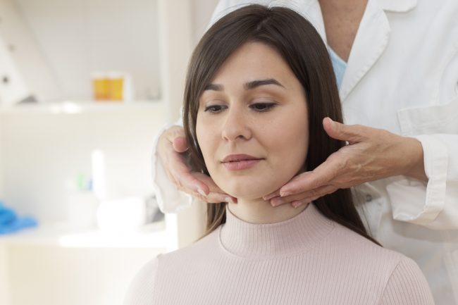 Demonstration of doctor examining patient neck